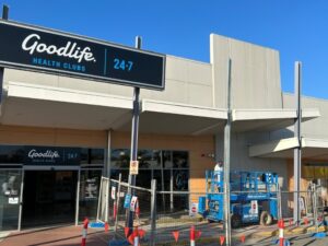 Exterior of Goodlife Health Club being prepared for commercial painting with equipment, highlighting cost estimation factors.